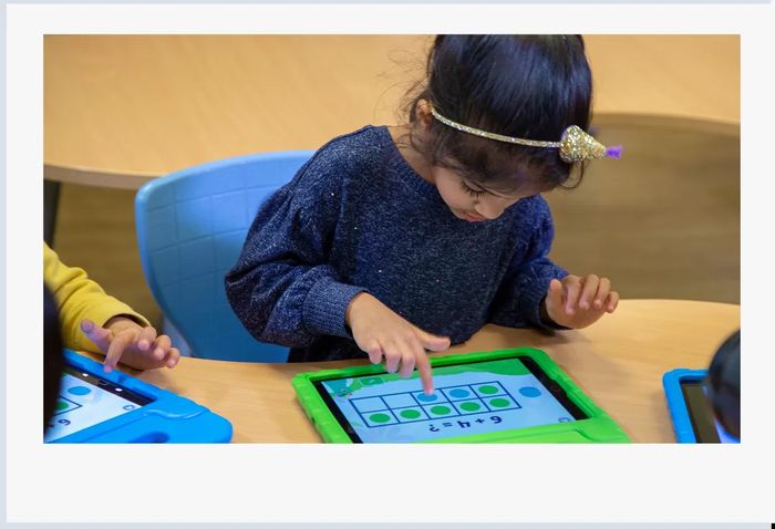 Young girl using the Khan Academy Kids app on a tablet to build early math skills.