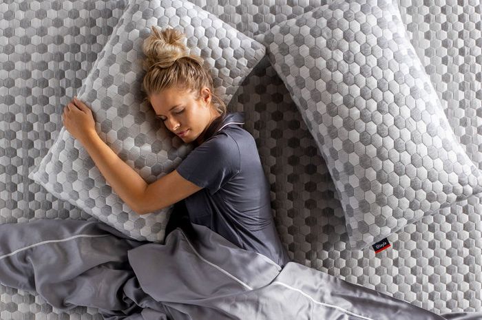 Layla Kapok Pillow - Woman hugging Kapok Pillow while lying down on a mattress