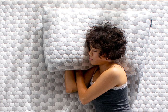Layla Kapok Pillow - Woman sleeping on a mattress, resting her head on a Kapok Pillow